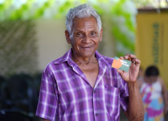 Famílias de Divinópolis são beneficiadas com Aluguel Social nesta segunda-feira - homem negro de aproximadamente 70 anos segurando cartão do Aluguel Social