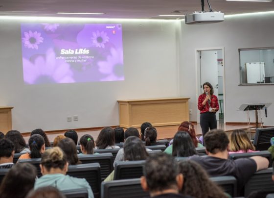 O Hospital Estadual de Urgências Governador Otávio Lage de Siqueira (Hugol) inaugurou, nesta quinta-feira (28/05), sua Sala Lilás, espaço destinado ao acolhimento e apoio de mulheres vítimas de violência. A iniciativa tem como objetivo fortalecer a assistência humanizada e garantir um atendimento mais seguro, reservado e acolhedor às vítimas atendidas. A Sala Lilás foi estruturada para oferecer privacidade, escuta qualificada e suporte durante o atendimento multiprofissional. O ambiente também poderá ser utilizado em atendimentos que que também envolvam crianças e adolescentes em situação de vulnerabilidade. O evento reuniu 168 profissionais do hospital, entre equipes assistenciais, multiprofissionais e setores estratégicos, reforçando a importância da qualificação contínua para o atendimento humanizado e identificação precoce de situações de violência. A inauguração contou com palestra voltada aos profissionais, ministrada pela coordenadora-geral dos Ciclos de Vida e Violências na Superintendência de Políticas e Atenção Integral à Saúde da Secretaria da Saúde de Goiás, Lígia da Fonseca Bernardes. Ela abordou temas relacionados ao enfrentamento da violência contra a mulher, incluindo: fluxo de atendimento dos casos; violência de gênero; Lei Maria da Penha; tipos de violência; ciclo da violência; identificação de sinais de abuso e vulnerabilidade. Capacitção das equipes Segundo Lígia, a capacitação das equipes de saúde é fundamental para garantir acolhimento adequado às vítimas. “Os profissionais da saúde têm papel essencial na identificação precoce dos sinais de violência e no acolhimento humanizado dessas mulheres”. “Muitas vezes, o hospital é a primeira porta de apoio procurada pela vítima, e estar preparado para esse atendimento pode fazer toda a diferença no rompimento do ciclo da violência”, destacou. Sala Lilás – avanço no cuidado De acordo com a supervisora multiprofissional do Hugol, Gabriela Vieira, a implantação da Sala Lilás representa um avanço importante no cuidado às vítimas em situação de vulnerabilidade. “A criação desse espaço fortalece o acolhimento humanizado dentro da unidade e proporciona mais segurança, privacidade e suporte emocional às pacientes atendidas. É um ambiente pensado para oferecer escuta qualificada e assistência integral”, afirmou. A criação da Sala Lilás integra as ações de fortalecimento das políticas de proteção e cuidado às vítimas de violência desenvolvidas pelo Hugol, promovendo um ambiente mais acolhedor e preparado para assistência integral aos pacientes em situação de vulnerabilidade. Além do acolhimento imediato, o espaço também busca contribuir para o encaminhamento adequado das vítimas à rede de apoio e proteção, fortalecendo o trabalho integrado entre saúde, assistência social e segurança pública. Saiba mais Sala Lilás do Hugol vai acolher mulheres vítimas de violência