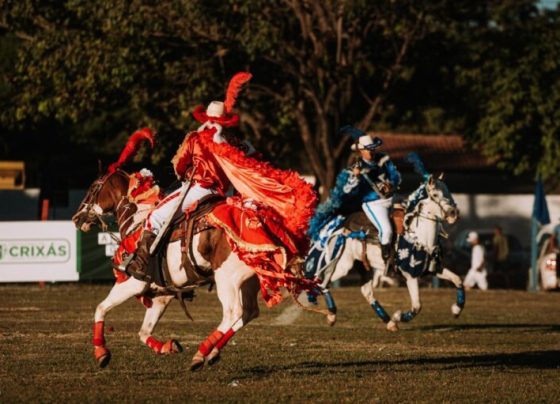 Cavalhadas de Crixás preservam tradição centenária em Goiás - encenação da batalha entre mouros e cristãos - cavaleiros em cavalos brancos e vestindo trajes nas cores azul e vermelha