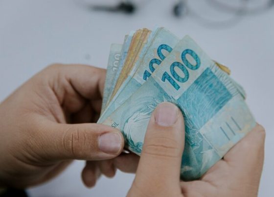 Nota Fiscal Goiana: começa prazo para resgate dos prêmios do sorteio de maio - notas de 50 e 100 reais na mão de uma pessoa